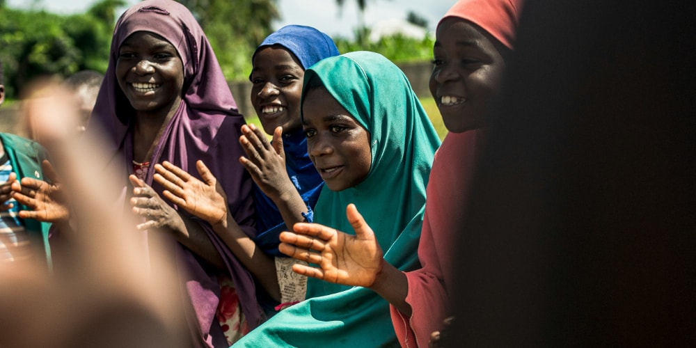 group of smiling women clapping next to each other